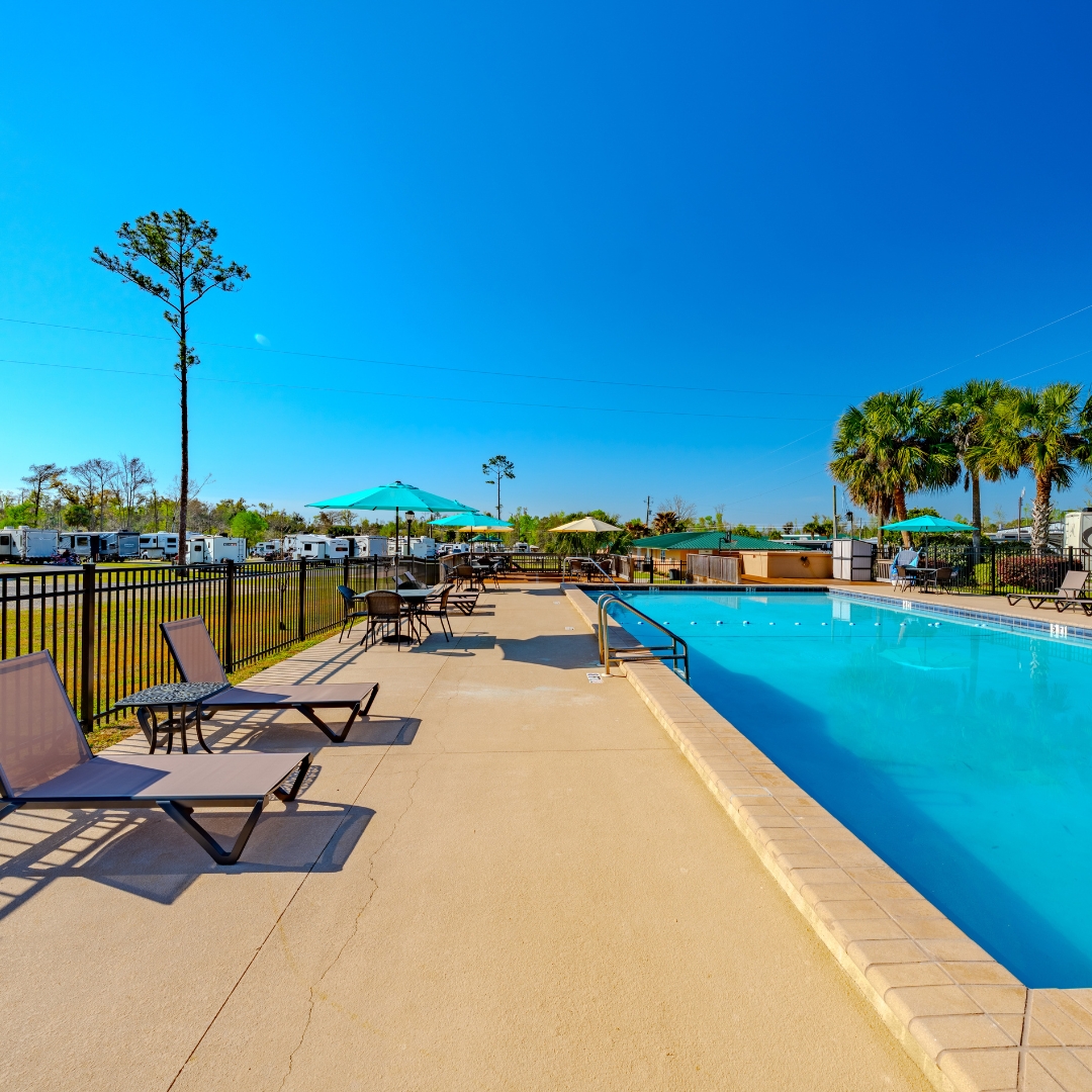 Outdoor pool at Florida Caverns RV Resort with lounging chairs